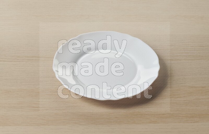 A white ceramic circular plate on light wooden background
