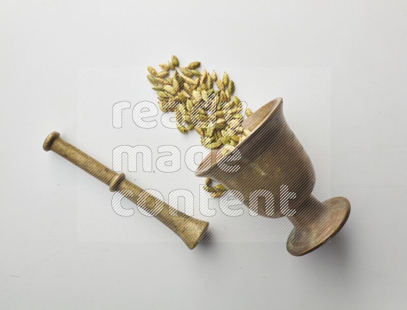 Top-view shot of Cardamon in herbs crusher on white background