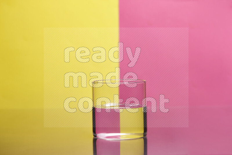 The image features a clear glassware filled with water, set against yellow and pink background