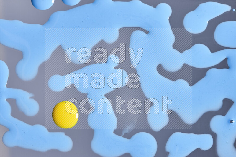 لقطات مقربة لقطرات من اللون الأزرق والأصفر على الخلفية