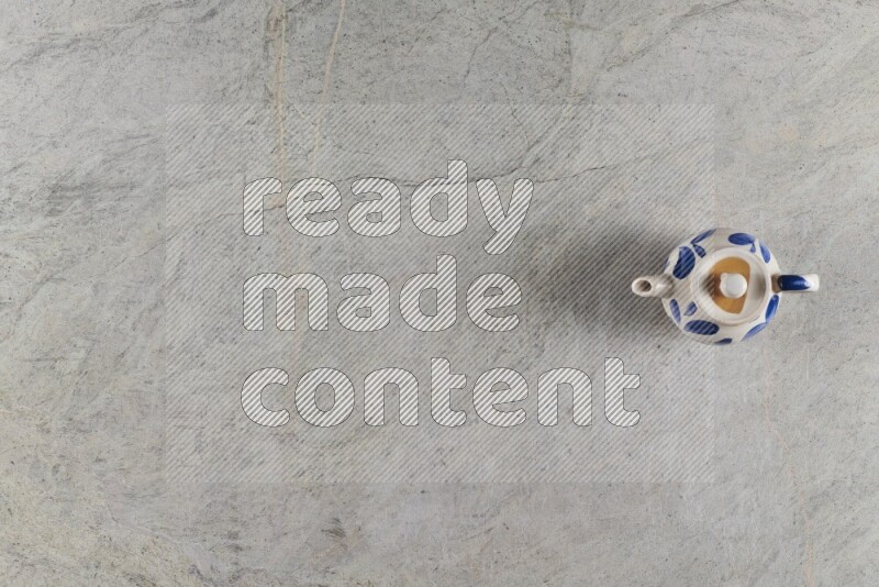 A pottery teapot on grey marble background