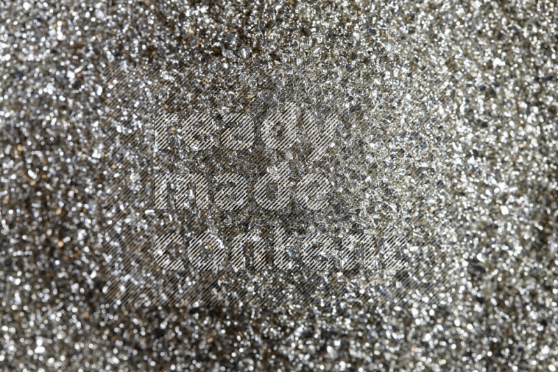 Silver shimmering fragments of glass scattered on a black background