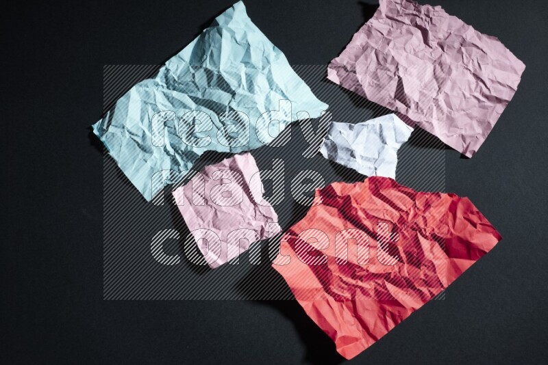Crumpled multicolored paper on black background