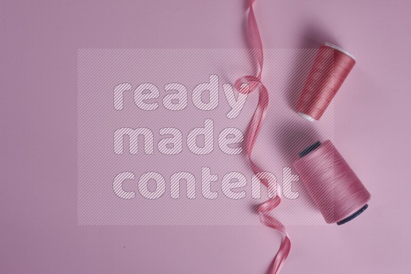 مجموعة من أدوات الخياطة والتفصيل زهرية اللون على خلفية زهرية