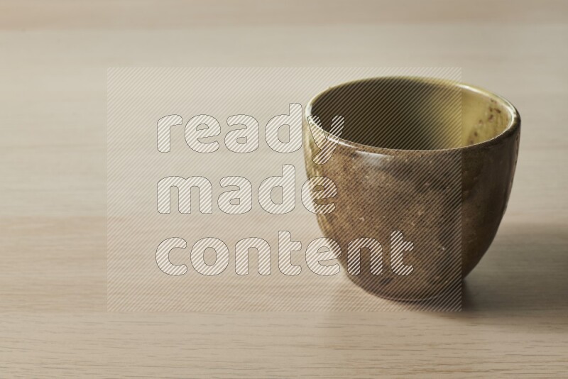 A multicolored pottery bowl on light wooden background