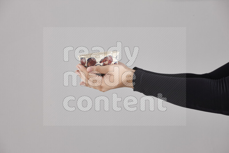 امرأة ترتدي عباءة سوداء تحمل أدوات فخارية مختلفة في أوضاع متعددة