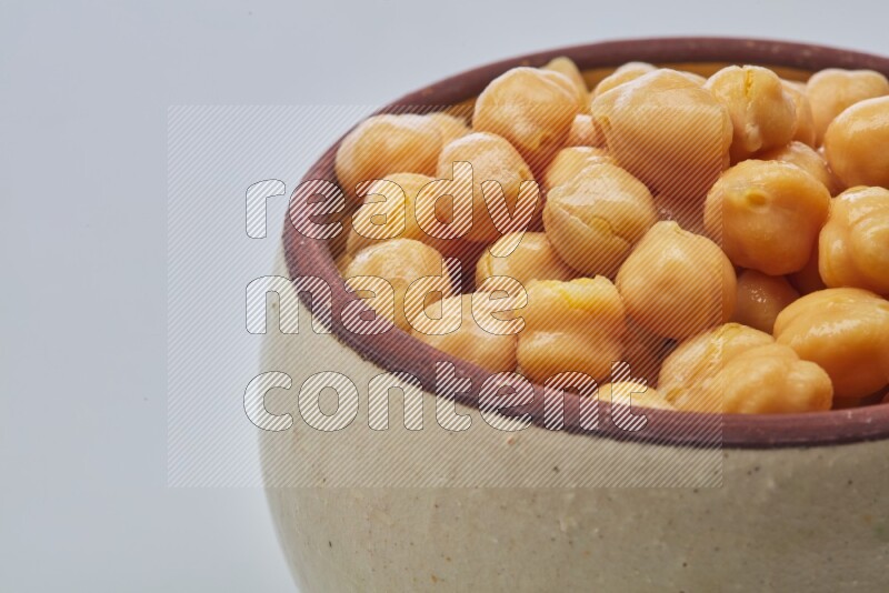 Close up of a boiled chickpeas in a container on white background