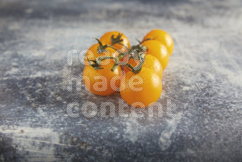 yellow cherry tomato vein on a textured rusty blue background 45 degree