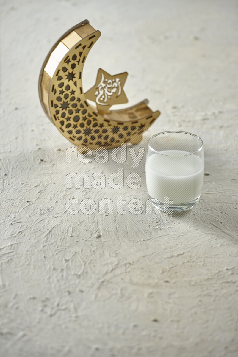 A wooden golden crescent lantern with different drinks, dates, nuts, prayer beads and quran on white background