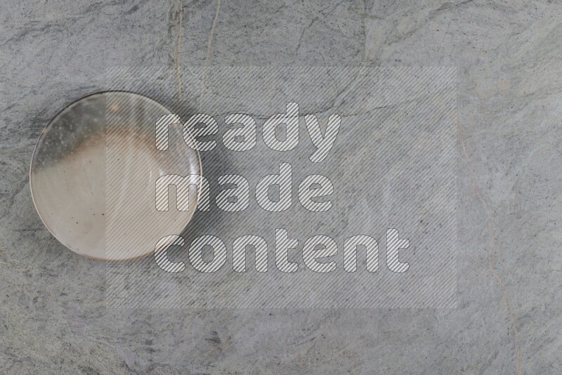 A multicolored pottery plate on grey marble background