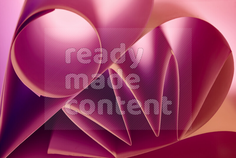 An artistic display of paper folds creating a harmonious blend of geometric shapes, highlighted by soft lighting in pink and warm tones