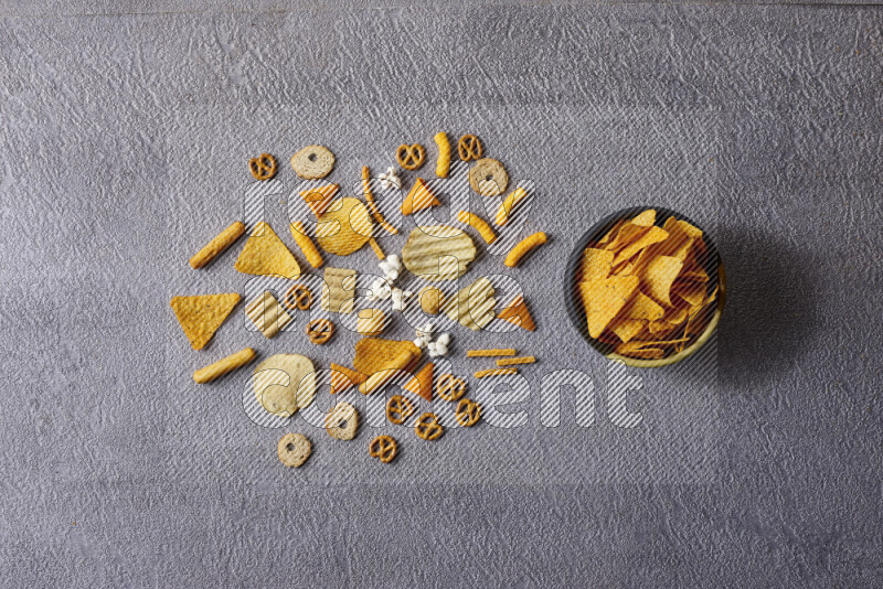 Assorted snacks in pottery bowls on grey background