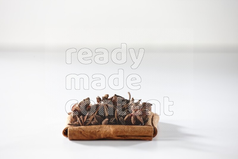 A single square of cinnamon sticks full of star anise on white flooring