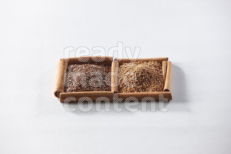 2 squares of cinnamon sticks full of mustard seeds and flaxseeds on white flooring