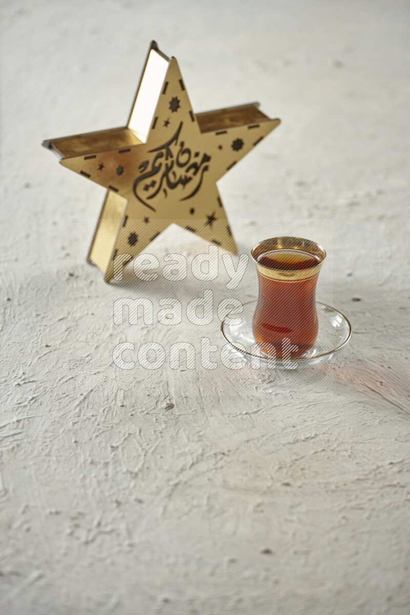 A wooden golden star lantern with different drinks, dates, nuts, prayer beads and quran on textured white background