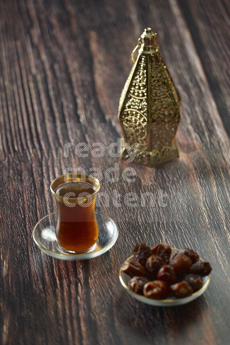 A golden lantern with different drinks, dates, nuts, prayer beads and quran on brown wooden background