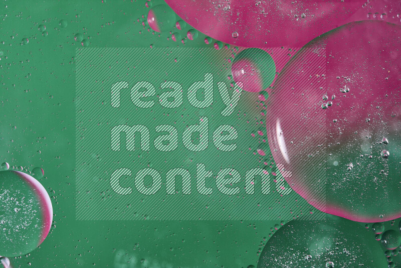 لقطات مقربة لفقاعات من الزيت على سطح الماء باللون الأخضر والوردي