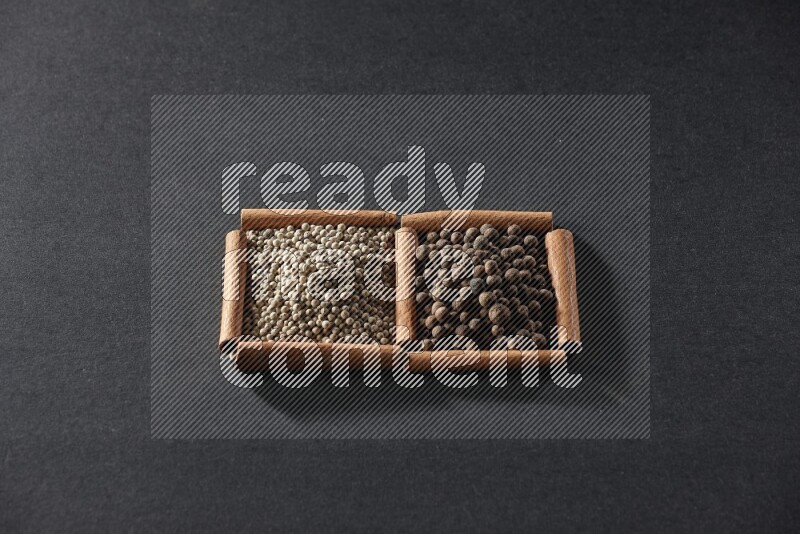 2 squares of cinnamon sticks full of white peppers and allspice on black flooring