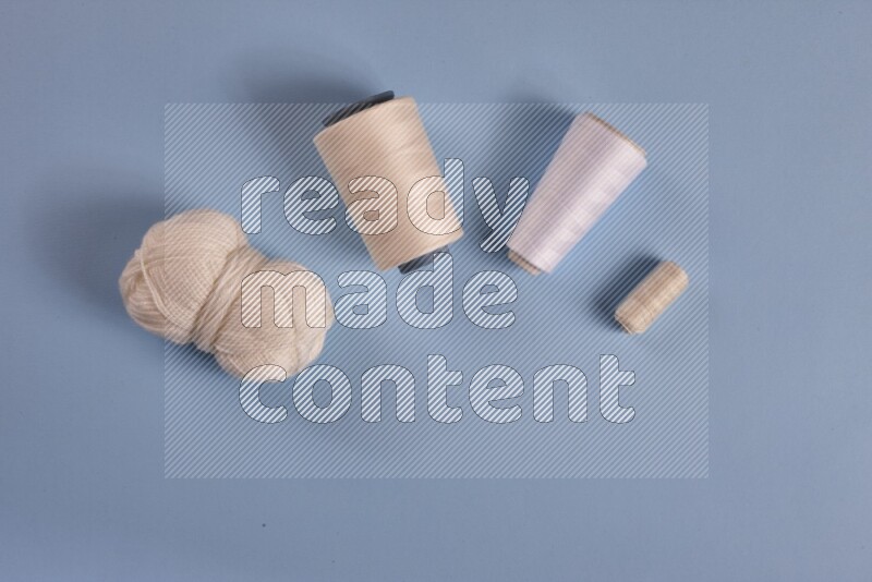 A white collection of sewing and tailoring tools arranged on a blue background