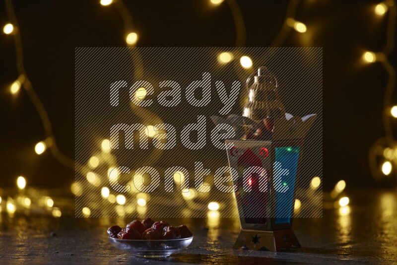 A traditional ramadan lantern surrounded by glowing fairy lights in a dark setup