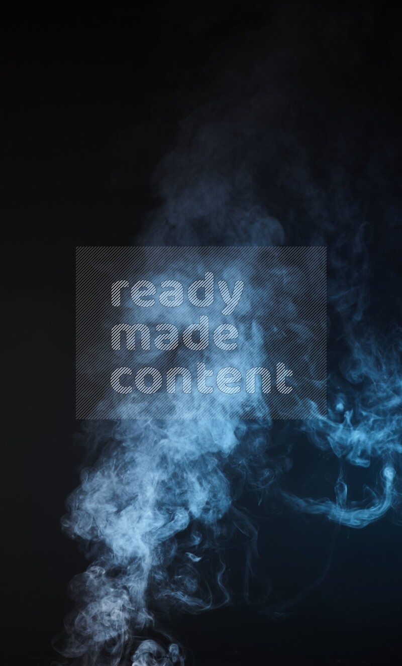 Heavy smoke in blue isolated on black background