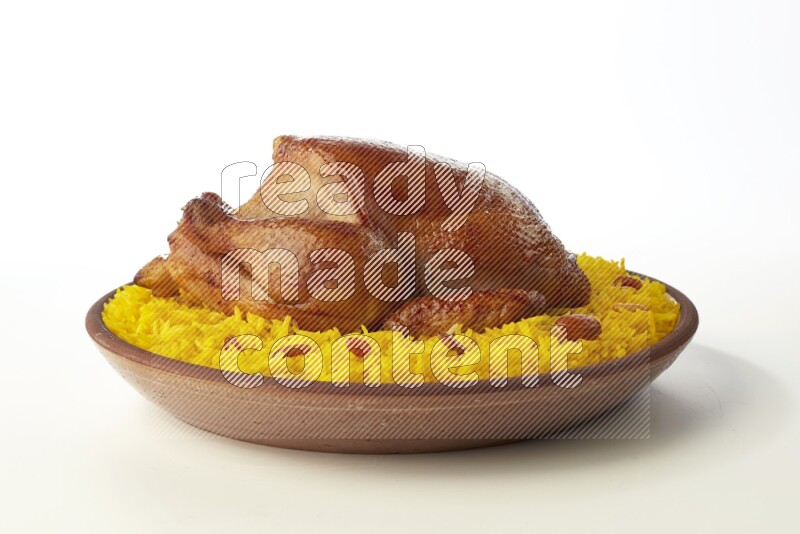 yellow basmati Rice with whole roasted chicken  on a pottery plate  direct  on white background