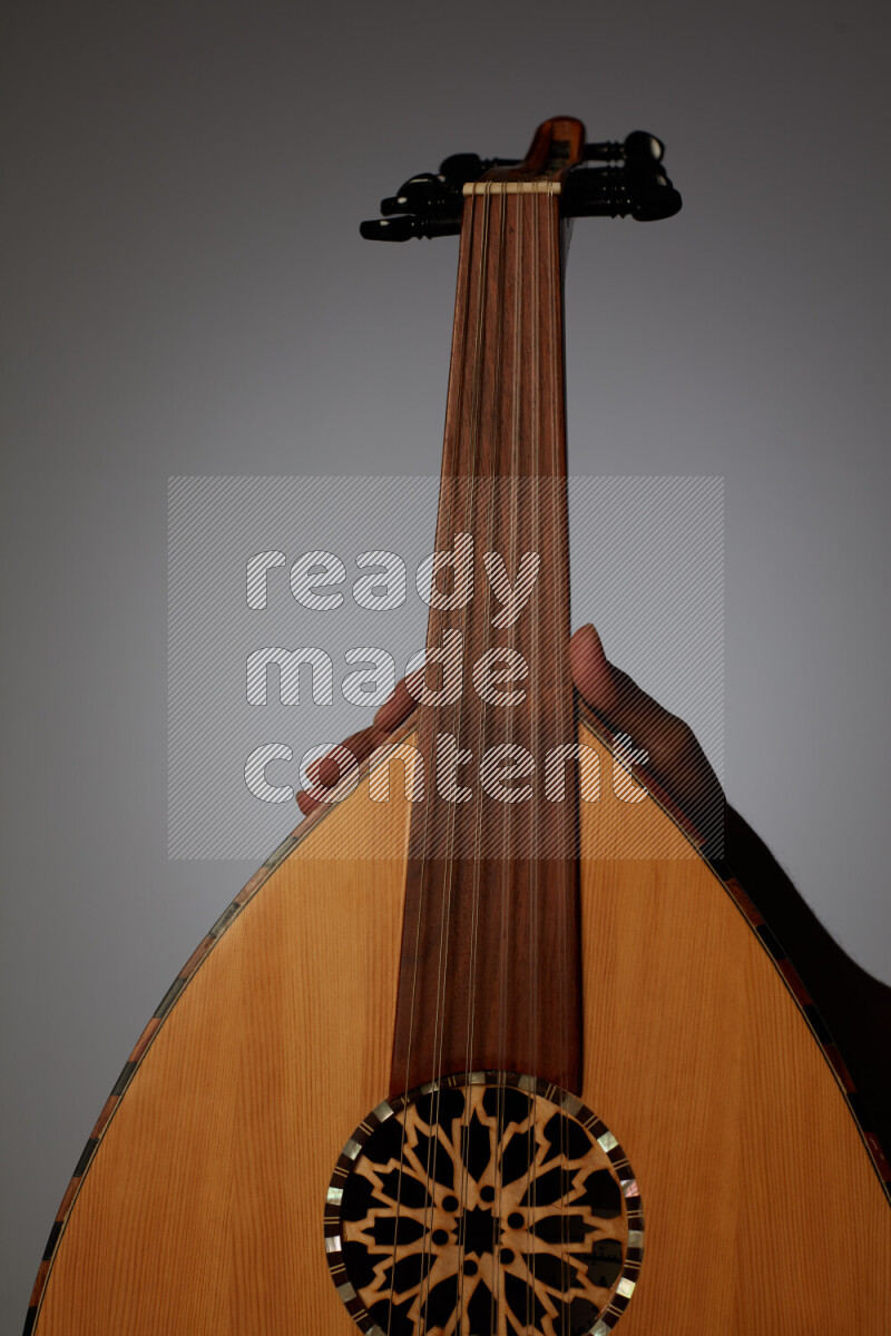 يد رجل تعزف على عود خشبي بني