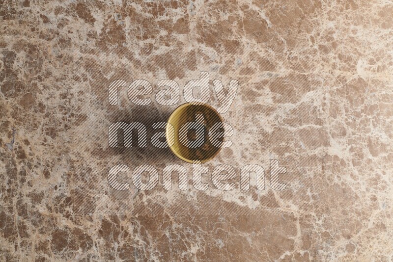 A multicolored pottery cup on beige marble background