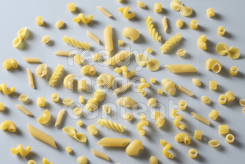 Different pasta types on light blue background