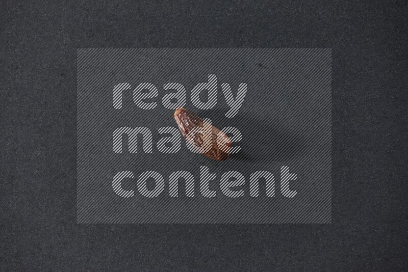 حبة واحدة من البلح المجفف علي خلفية سوداء