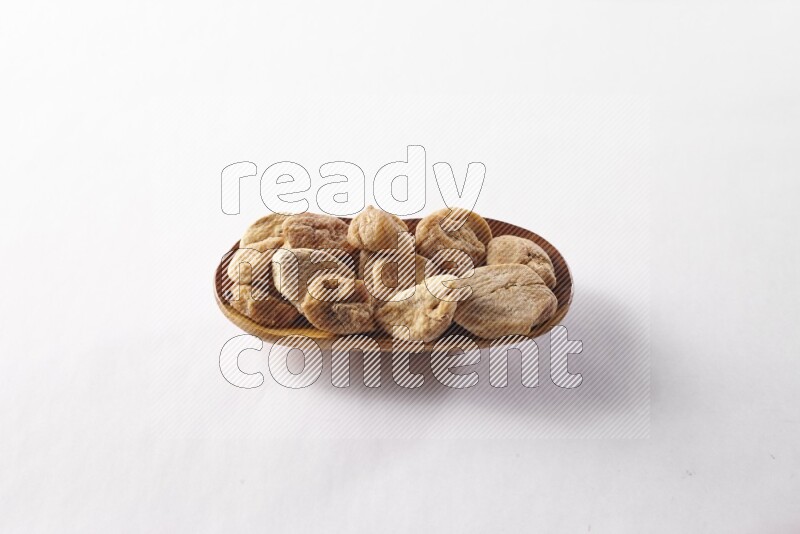 Dried figs in a wooden plate on white background