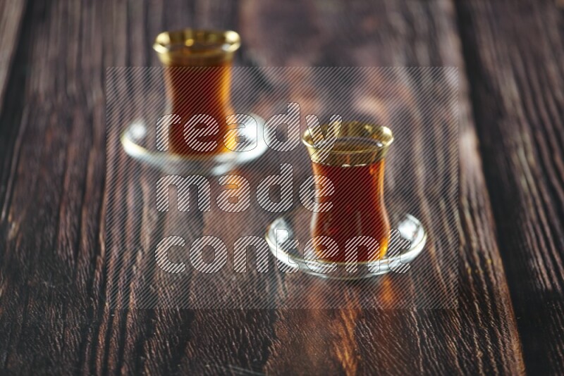 A tea glass cup with dates and coffee on wooden background