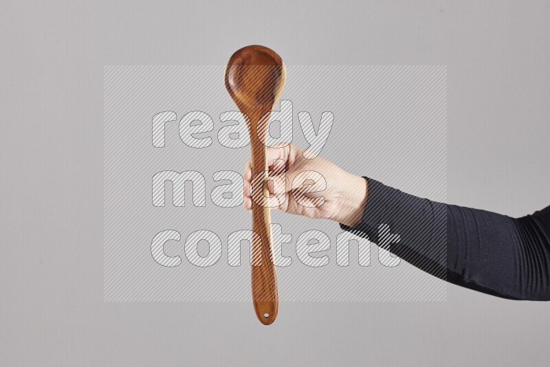 امرأة ترتدي عباءة سوداء تحمل أدوات خشبية مختلفة في أوضاع متعددة