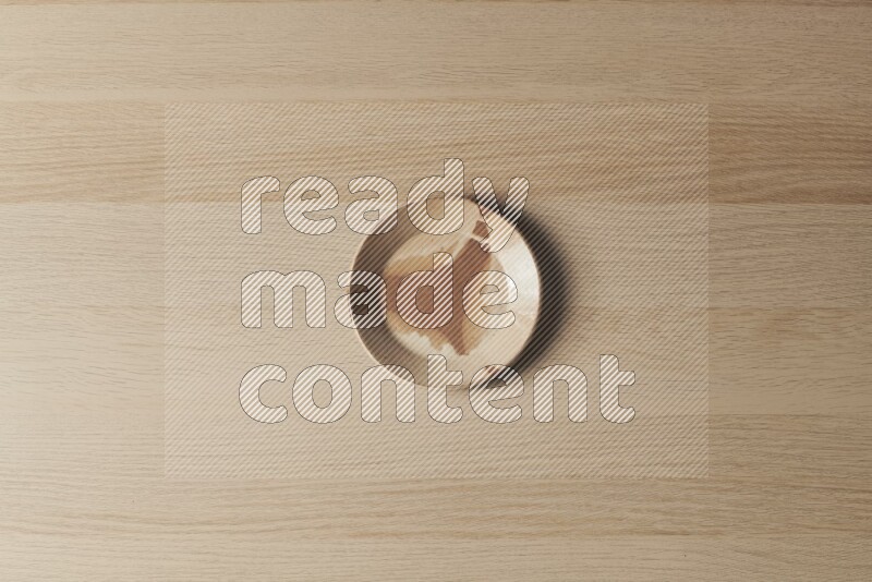 A multicolored pottery plate on light wooden background