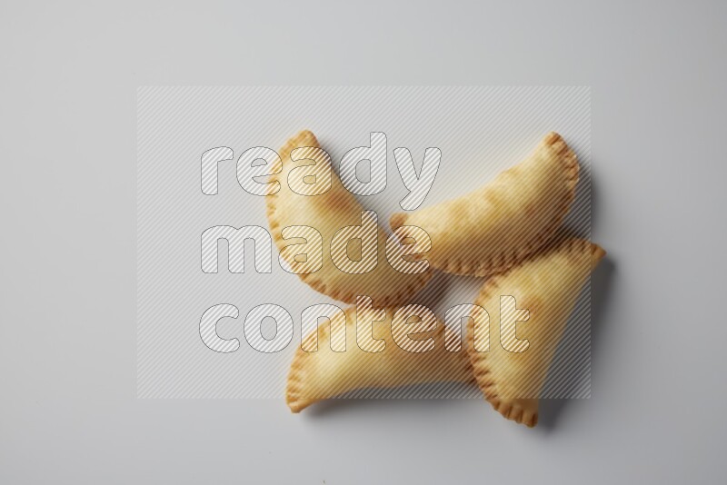 Four fried sambosa from a top angle on a white background