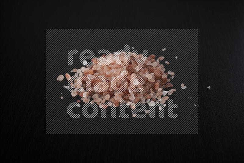 A bunch of coarse himalayan salt crystals on black background