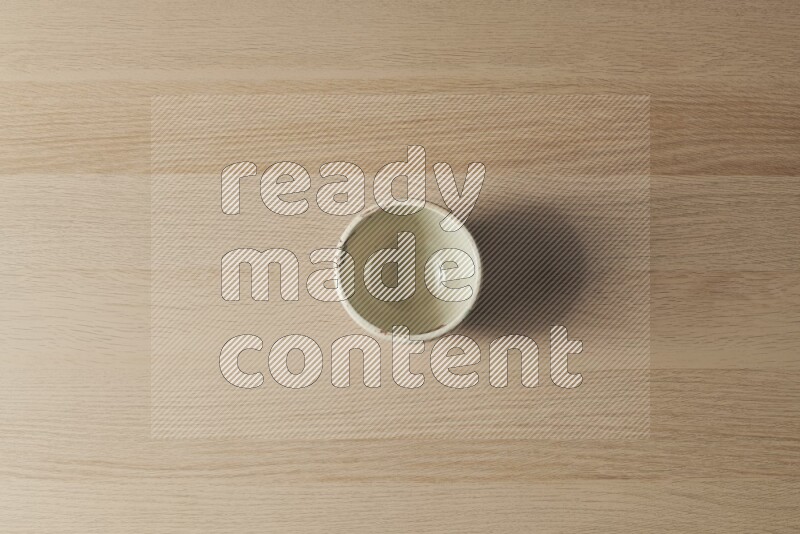 A white pottery bowl on light wooden background