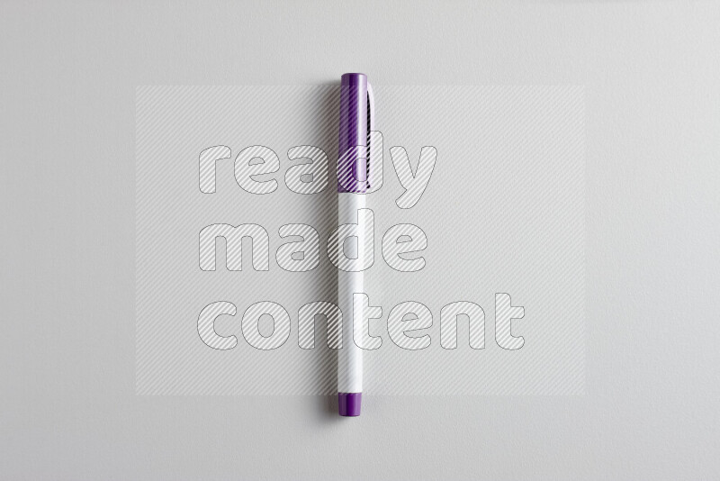 A close-up showing a single coloring pen with a cap on grey background