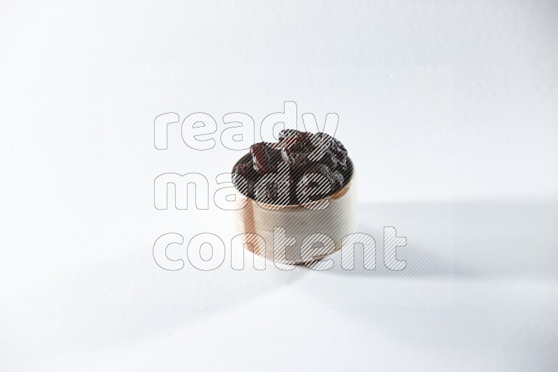 A beige ceramic bowl full of dried plums on a white background in different angles