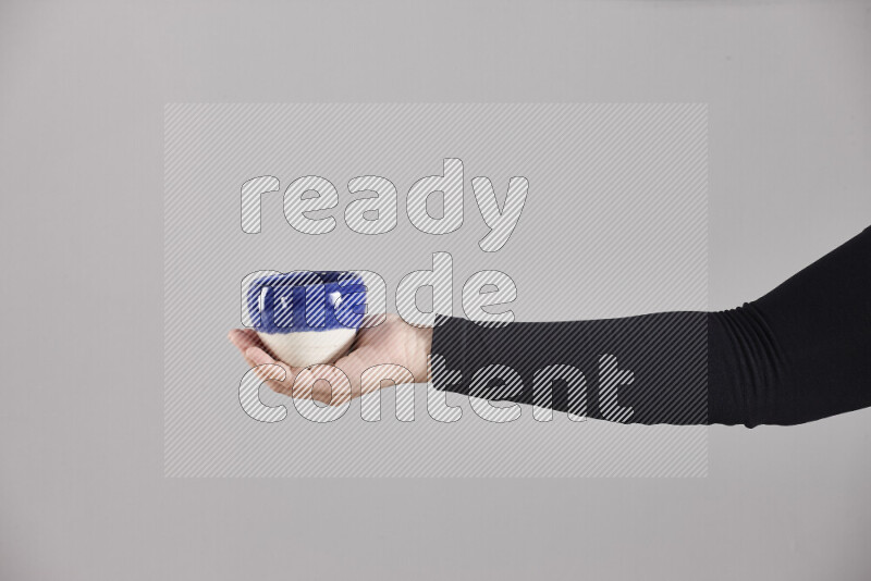 امرأة ترتدي عباءة سوداء تحمل أدوات فخارية مختلفة في أوضاع متعددة