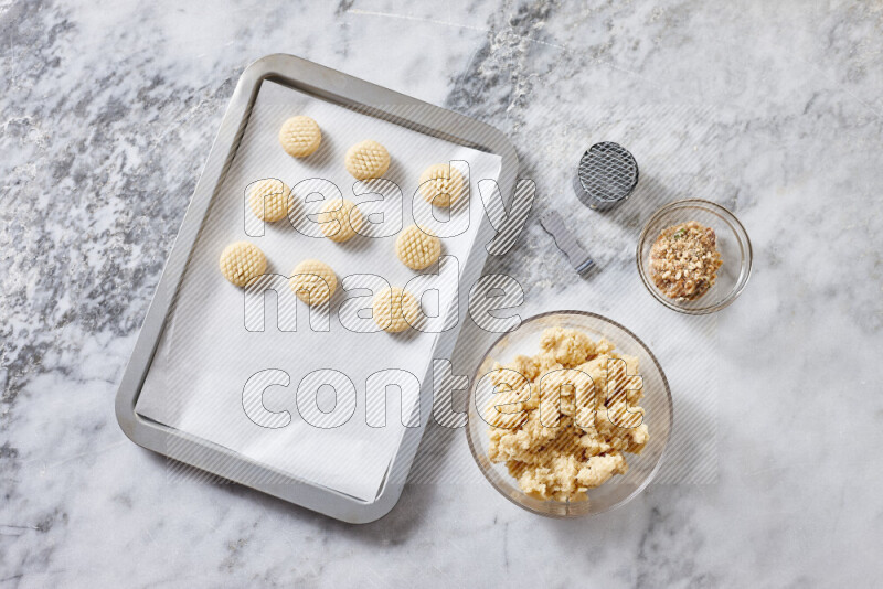 Kahk step by step with its ingredients ghee, sugar, flour, sesame, yeast, water and kahk flavor on grey marble background