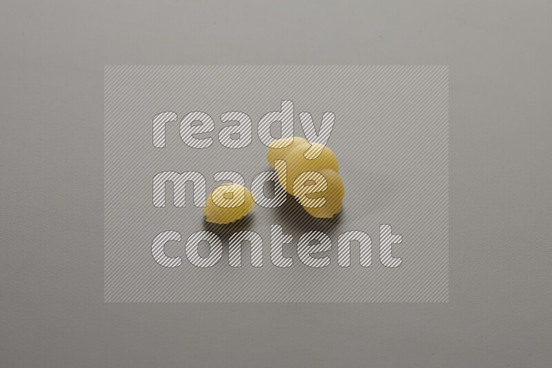 Shells pasta with other types of pasta on grey background