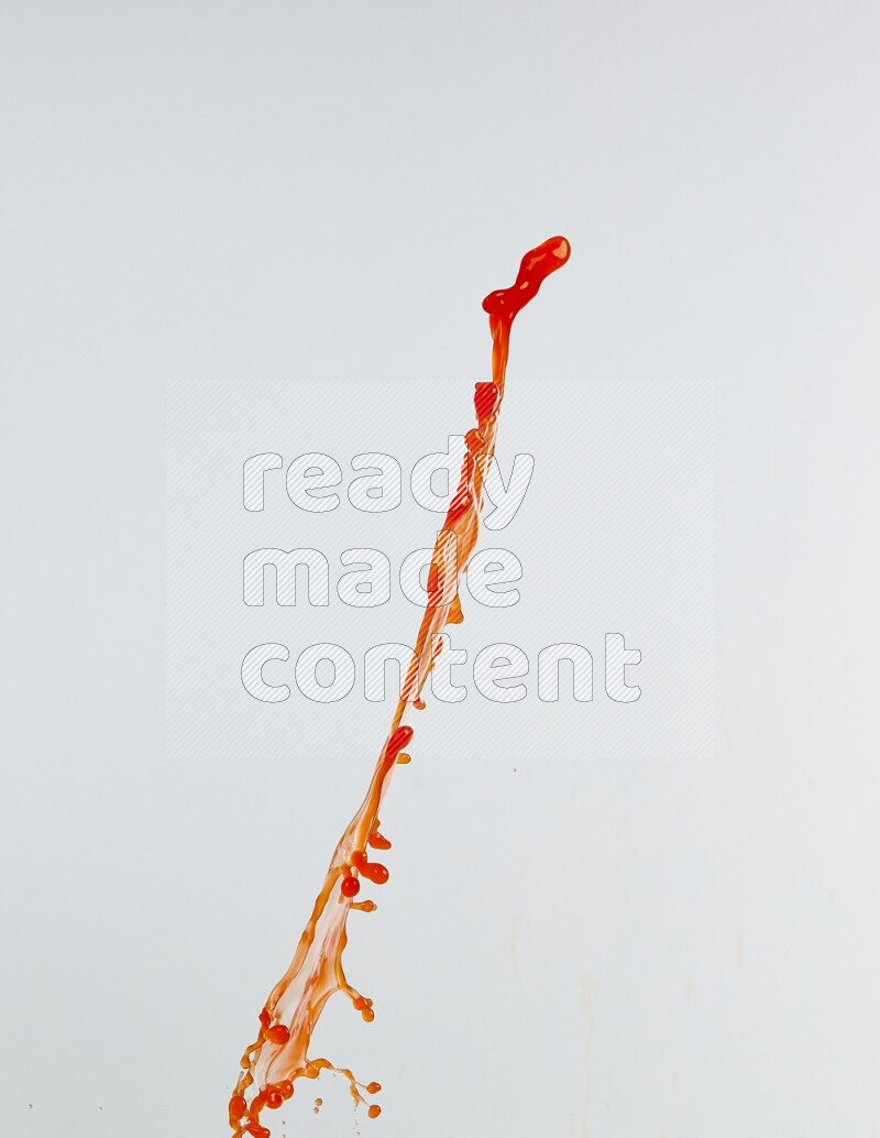 Orange liquid splash and drops on white background
