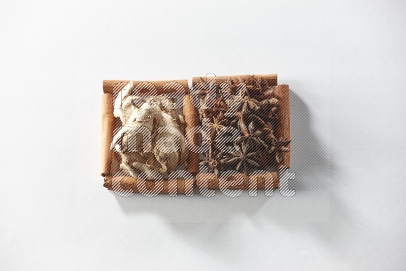 2 squares of cinnamon sticks full of star anise and dried ginger on white flooring