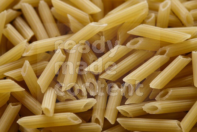 Mini penne pasta on grey background