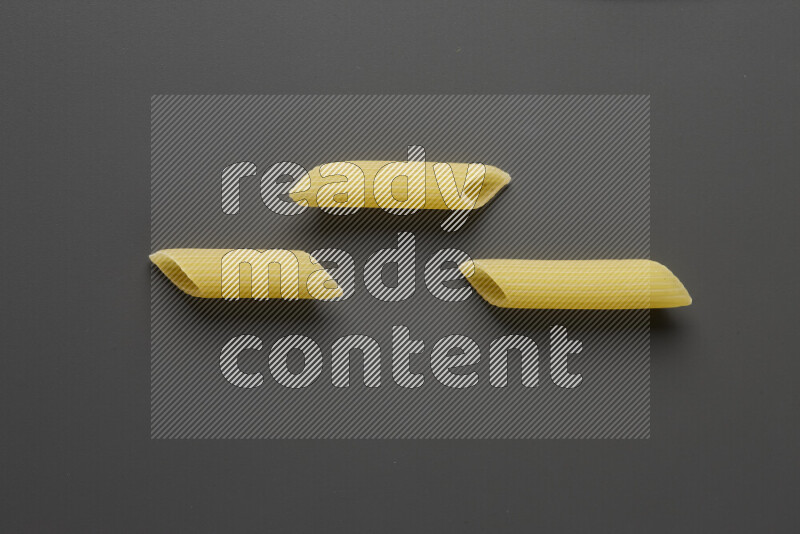 Penne pasta on grey background