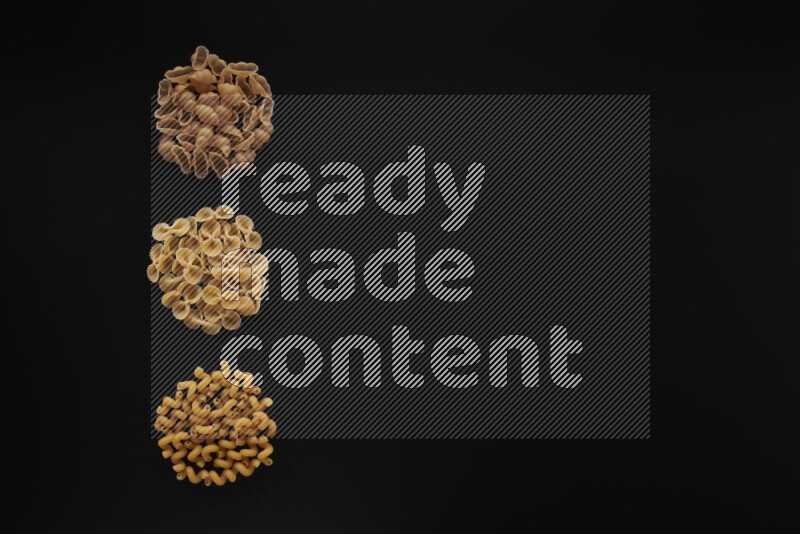 Different pasta types in 3 bunches on black background