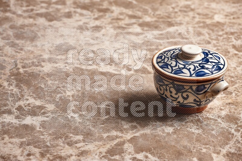 A decorative pottery bowl on beige marble background