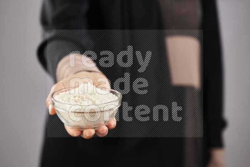 Woman in abaya holding different kinds of legumes in different positions