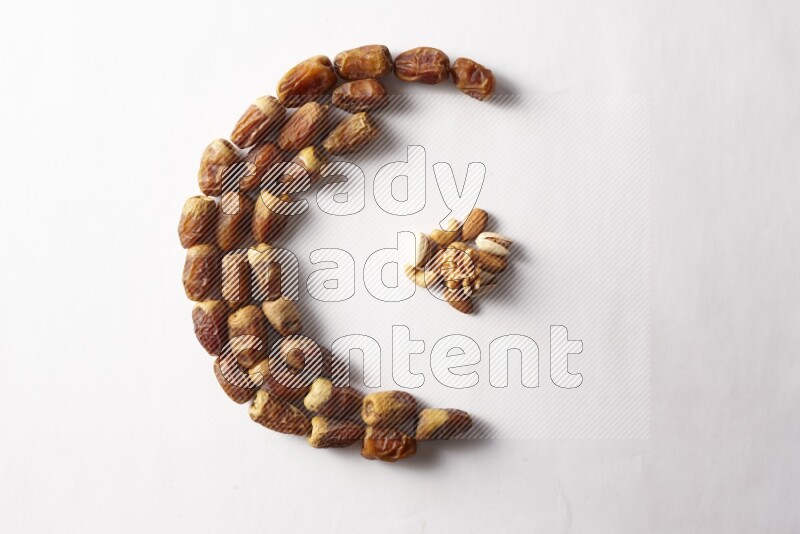 Dates in a crescent shape with nuts on white background
